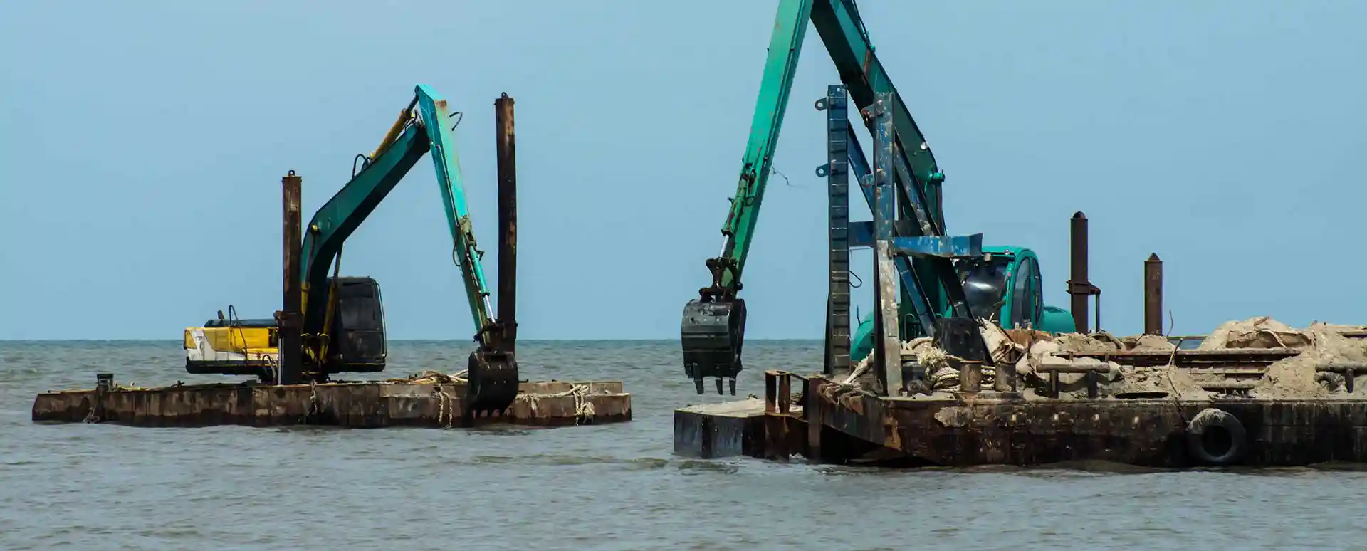 Two excavators in the water dredging contaminated soil