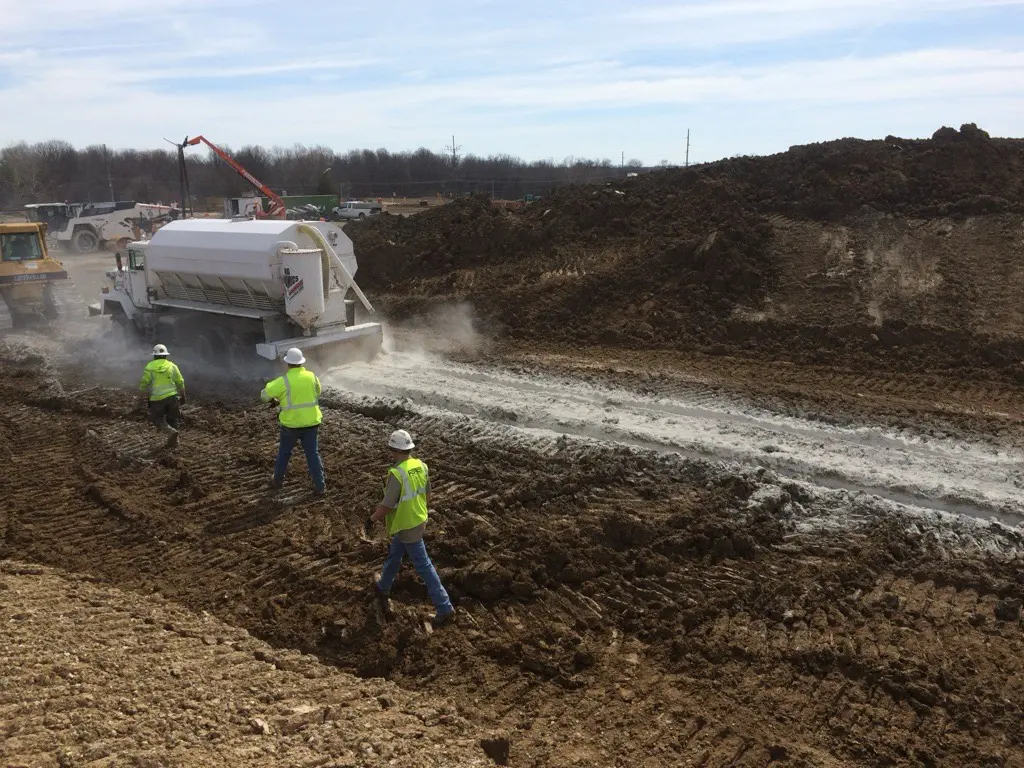 Spreader truck applying Quicklime to worksite