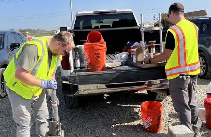 Two team members performing a geotechnical analysis on a project site