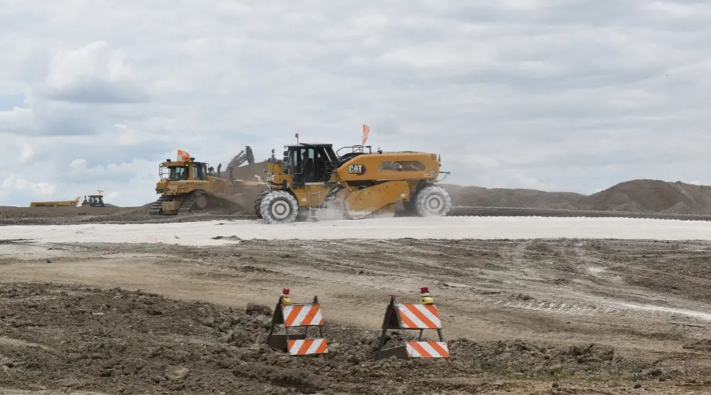 Modern high-horsepower reclaimer mixing lime into soil on jobsite